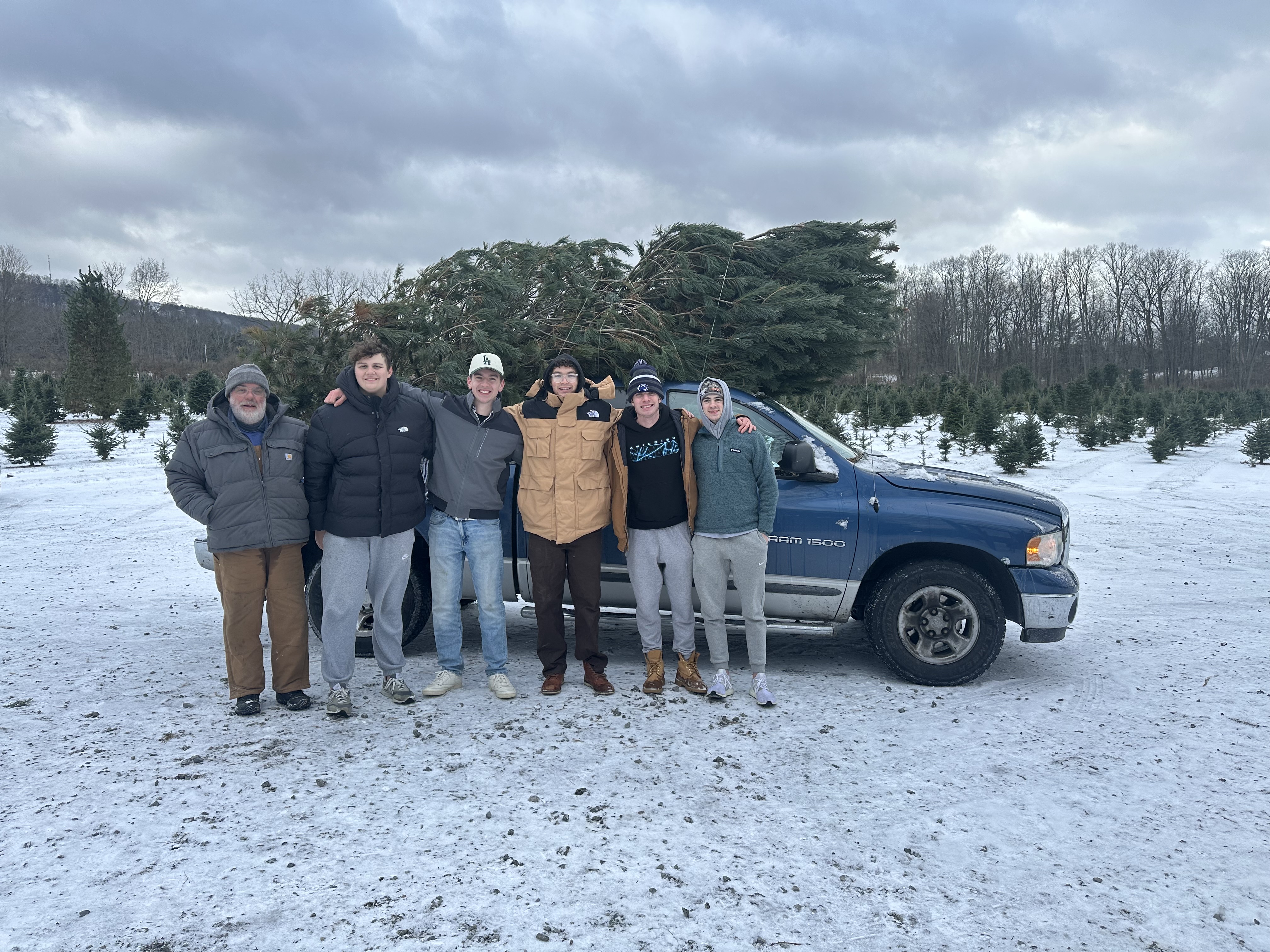 Family with their Christmas tree loaded on a truck